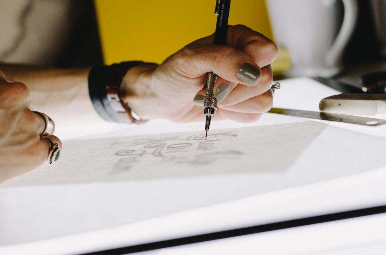 A woman drawing with a special typography pen